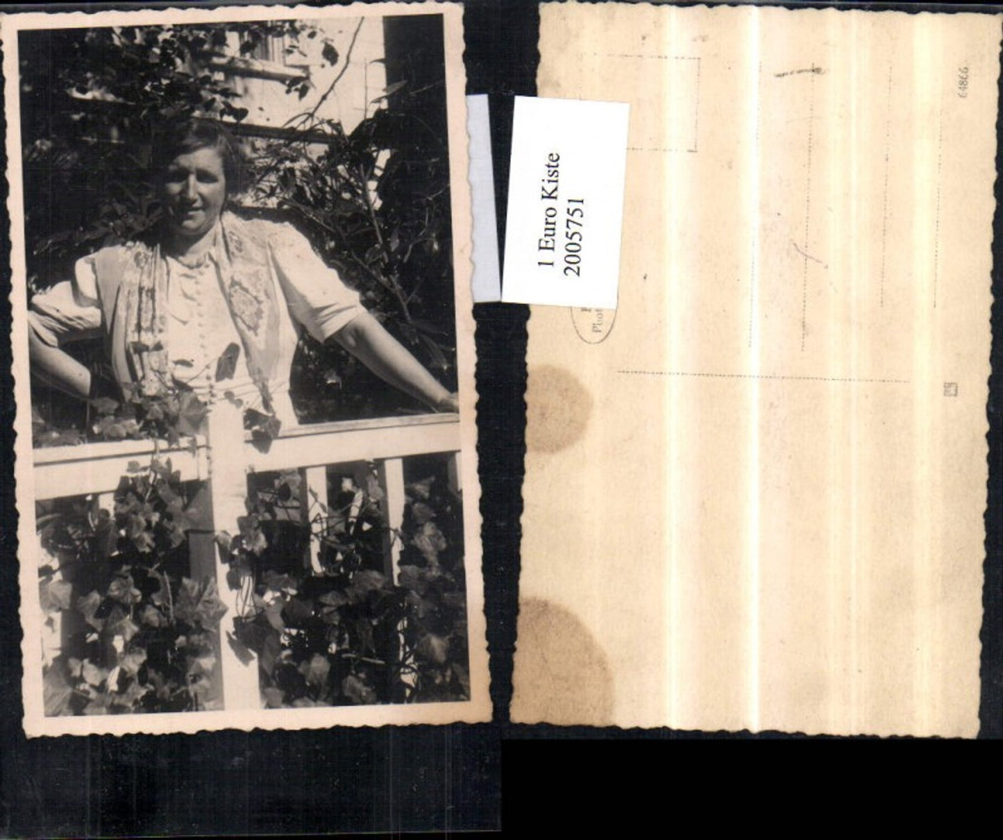 2005751,Foto AK Frau steht vor einem Zaun Efeu