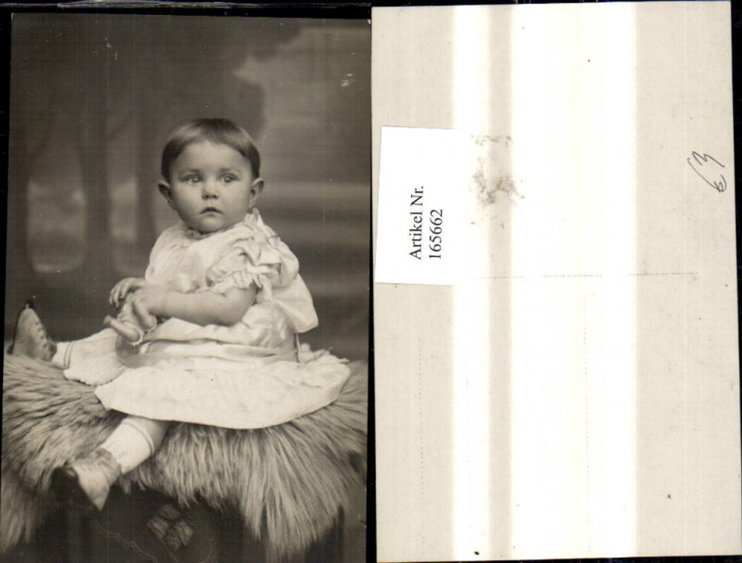 165662,Foto Ak Kind Mädchen i. Kleid m. Puppe a. Fell sitzend