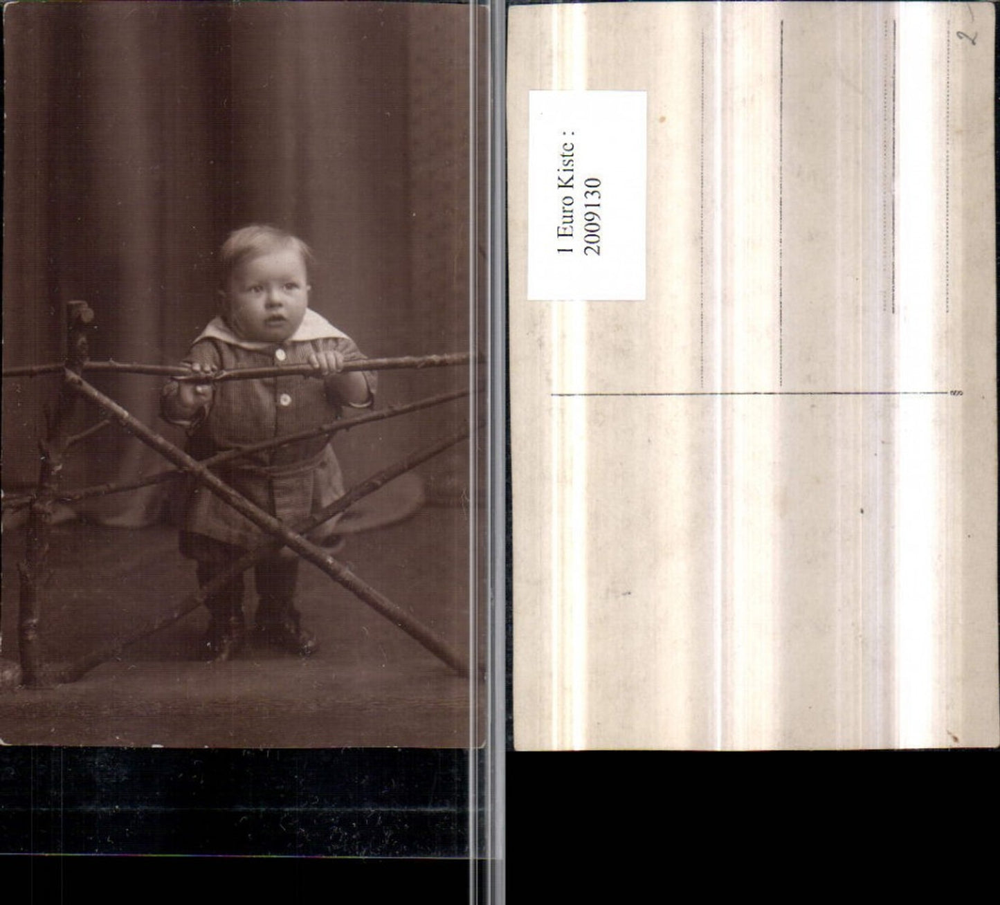 2009130,Foto AK Kind hält sich am Zaun Holzzaun fest