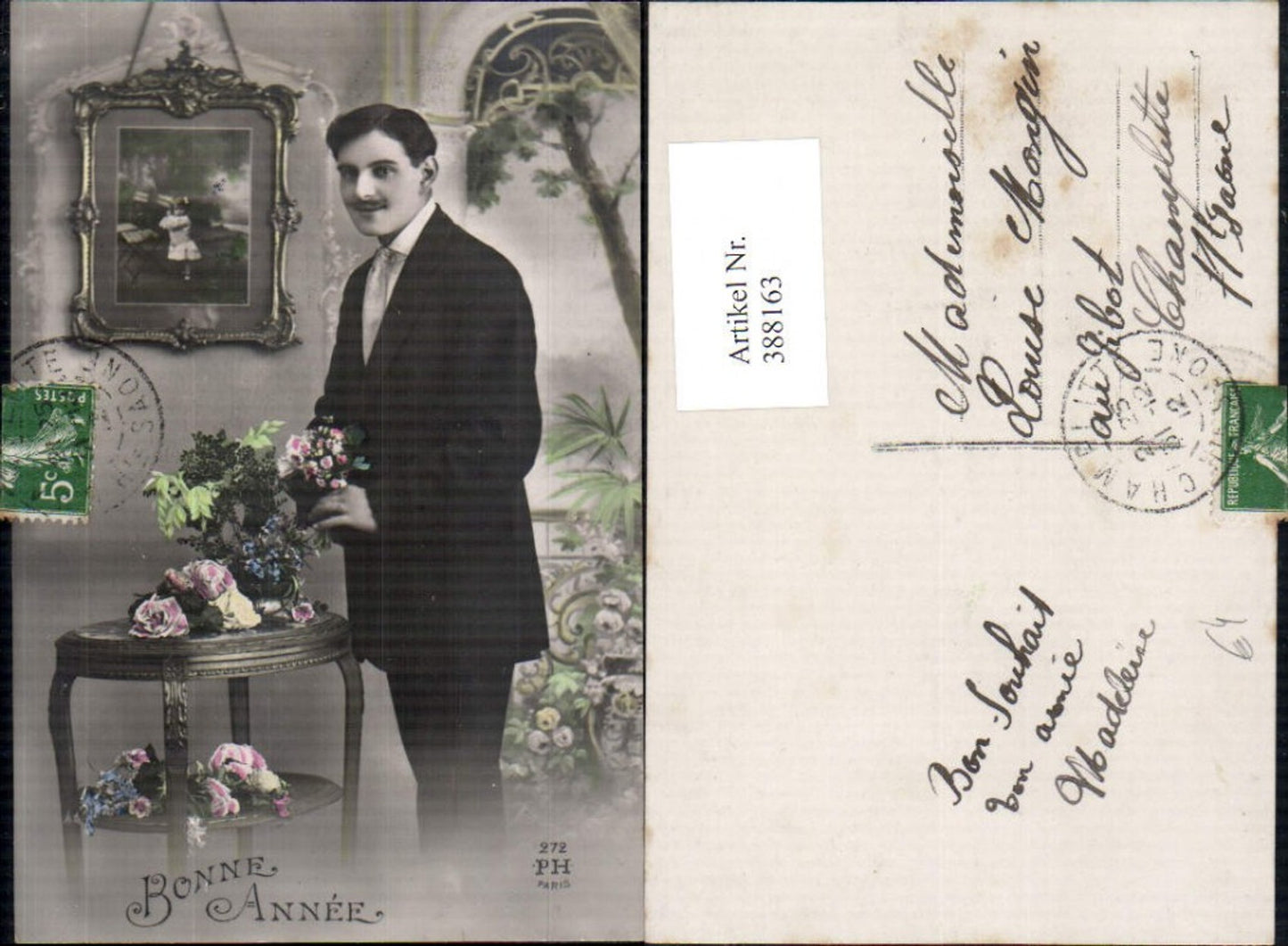 388163,Foto Ak Mann Anzug b. Tisch stehend Blumen Bild i. Hintergrund