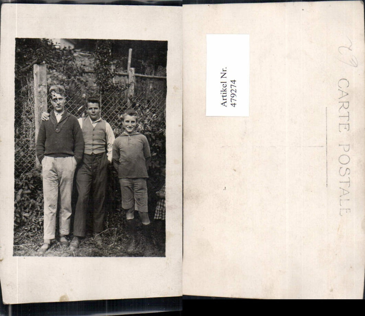 479274, Young men, boys, standing in front of a garden fence